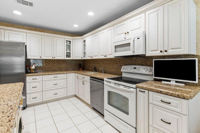 kitchen with light tile patterned floors, visible vents, stainless steel appliances, white cabinetry, and backsplash