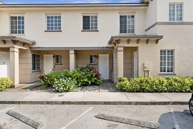 townhome / multi-family property featuring uncovered parking and stucco siding