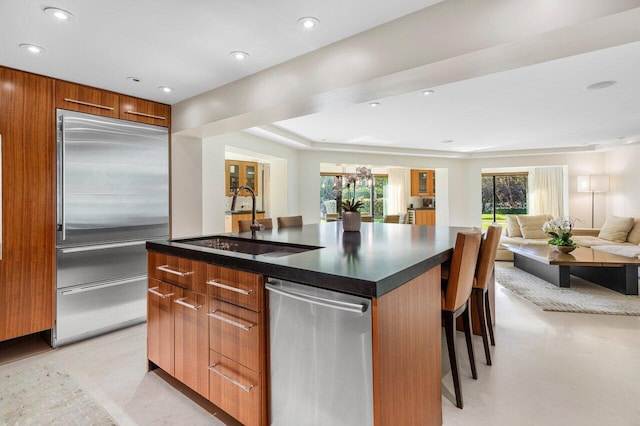 kitchen with dark countertops, a sink, stainless steel appliances, and modern cabinets