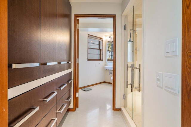 corridor featuring light floors and baseboards