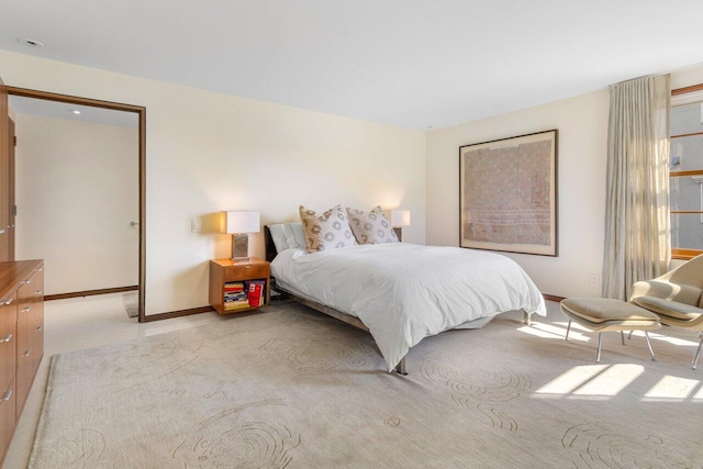 bedroom featuring baseboards and light carpet