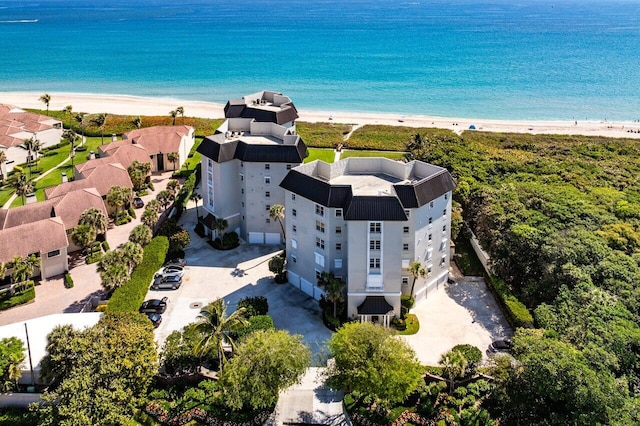 birds eye view of property with a water view and a beach view