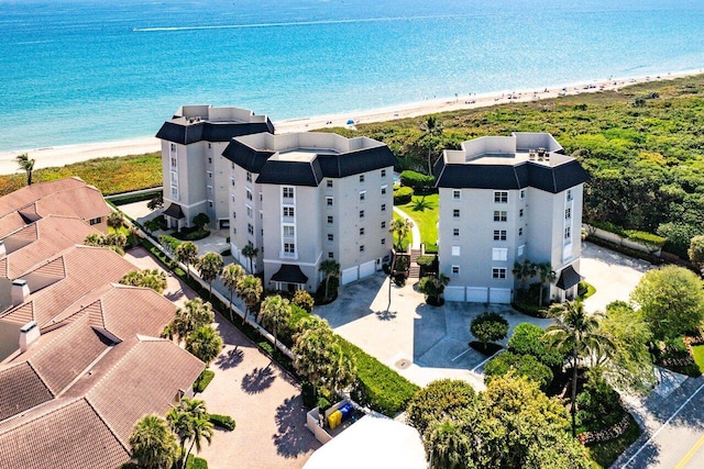 drone / aerial view featuring a water view and a view of the beach