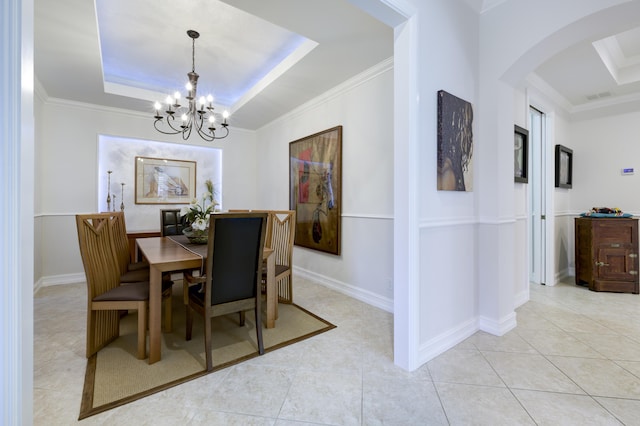 dining room with a tray ceiling, visible vents, and ornamental molding