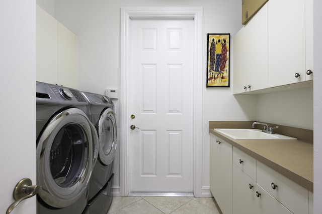 clothes washing area with light tile patterned floors, cabinet space, a sink, and washing machine and clothes dryer