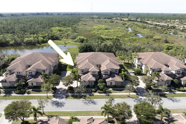 birds eye view of property featuring a forest view, a residential view, and a water view