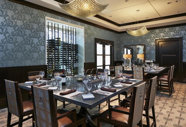 dining room with a wainscoted wall, ornamental molding, and wallpapered walls