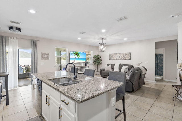 kitchen featuring recessed lighting, white cabinetry, a sink, and light tile patterned flooring