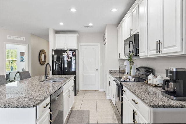 kitchen featuring visible vents, an island with sink, black appliances, white cabinetry, and a sink