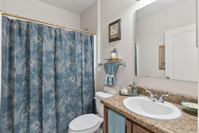 bathroom featuring a textured ceiling, curtained shower, vanity, and toilet