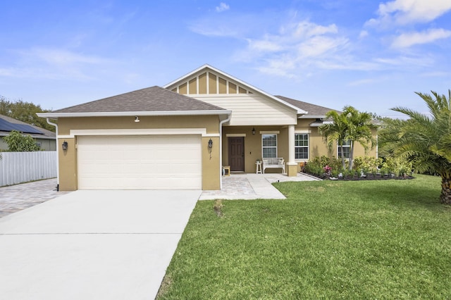 view of front of property with driveway, roof with shingles, an attached garage, fence, and a front lawn