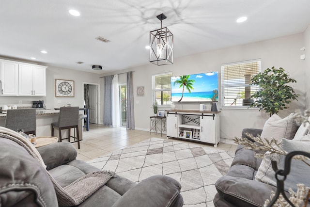 living area with light tile patterned floors, a chandelier, recessed lighting, visible vents, and baseboards