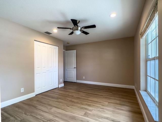 8389 Logia Cir, Boynton Beach, FL 33472 - unfurnished bedroom with a closet, baseboards, recessed lighting, light wood-style flooring, and visible vents