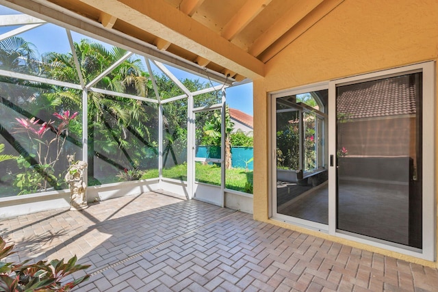 unfurnished sunroom featuring vaulted ceiling