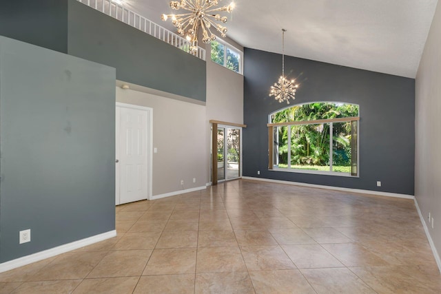 unfurnished room with high vaulted ceiling, tile patterned floors, baseboards, and an inviting chandelier