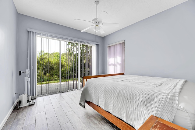 bedroom featuring access to outside, wood finished floors, a ceiling fan, and baseboards