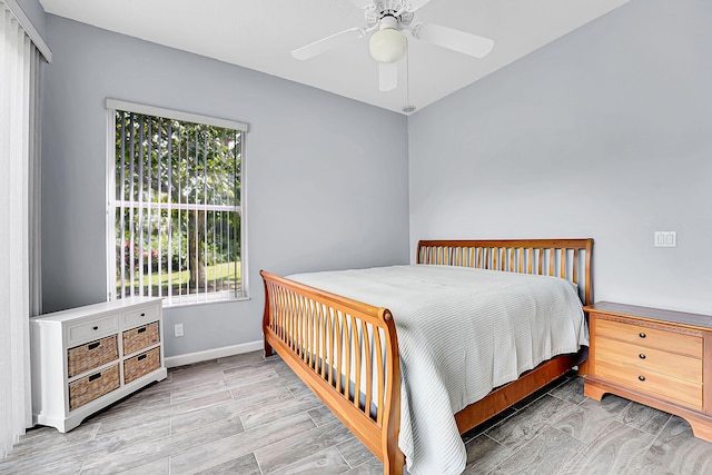 bedroom featuring ceiling fan, baseboards, and wood finished floors