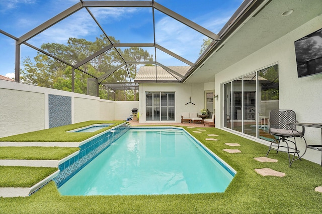 outdoor pool with a yard, a patio area, and glass enclosure