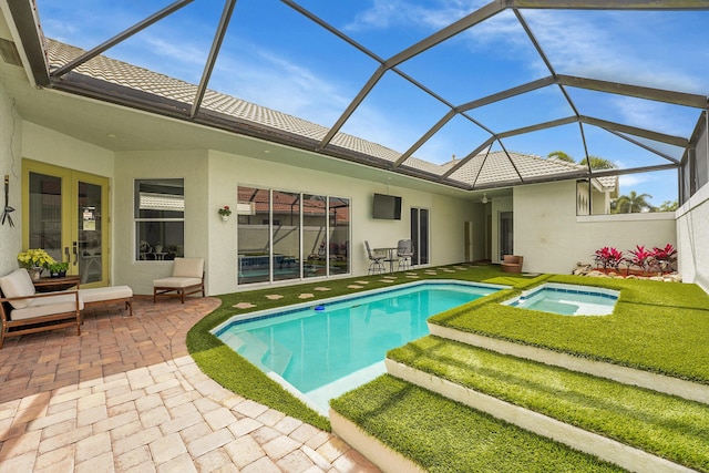 view of pool with a lanai, a pool with connected hot tub, and a patio