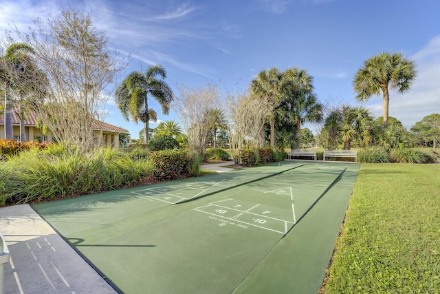 view of home's community featuring shuffleboard and a yard