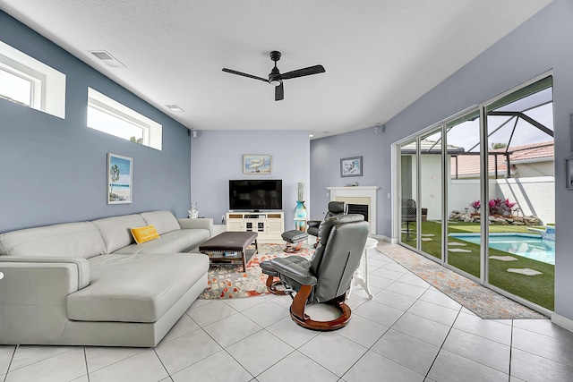 living area featuring a wealth of natural light, visible vents, a fireplace, and light tile patterned flooring