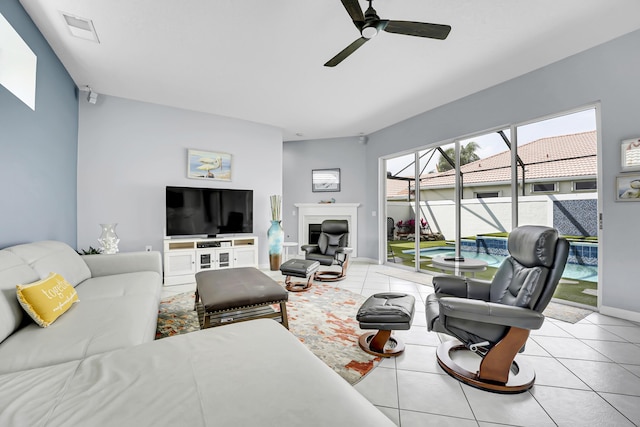 living area with baseboards, visible vents, a ceiling fan, a sunroom, and tile patterned floors