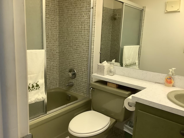 bathroom with toilet, vanity, and enclosed tub / shower combo