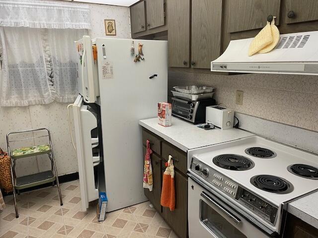 kitchen featuring a toaster, light countertops, decorative backsplash, white appliances, and under cabinet range hood