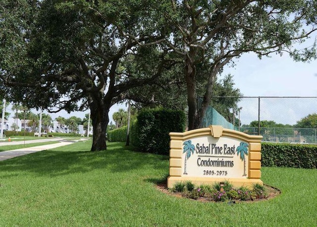 community sign with a lawn and fence