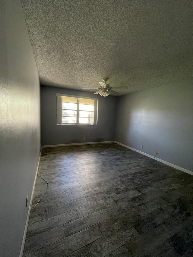 unfurnished room featuring baseboards, a ceiling fan, dark wood-style flooring, and a textured ceiling