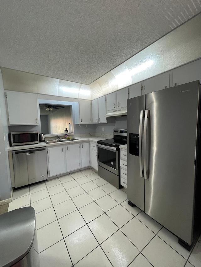 kitchen featuring light tile patterned flooring, stainless steel appliances, light countertops, and a sink