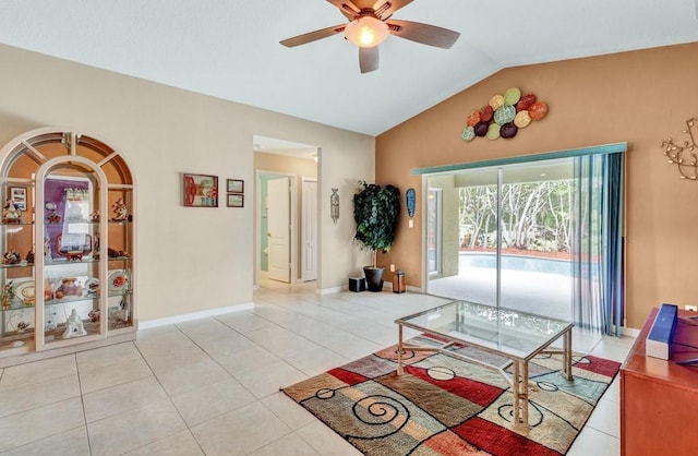 living area with light tile patterned floors, baseboards, vaulted ceiling, and a ceiling fan