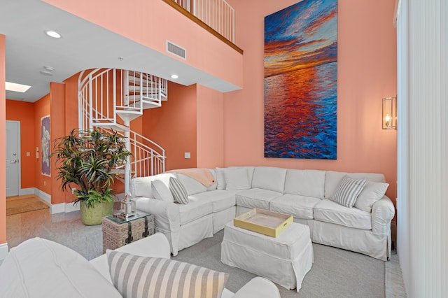 living room with visible vents, baseboards, a towering ceiling, stairway, and recessed lighting