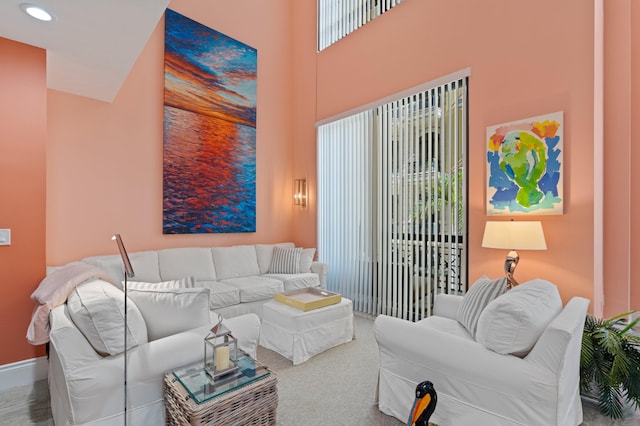 living room featuring recessed lighting, carpet flooring, a towering ceiling, and baseboards