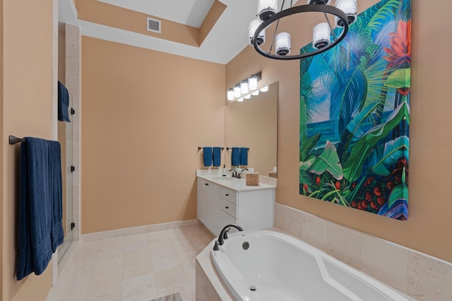 bathroom with baseboards, visible vents, tile patterned floors, a garden tub, and vanity