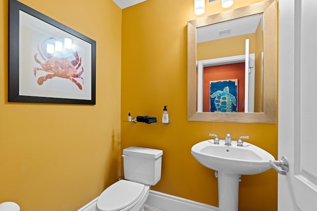 half bathroom featuring baseboards, visible vents, and toilet