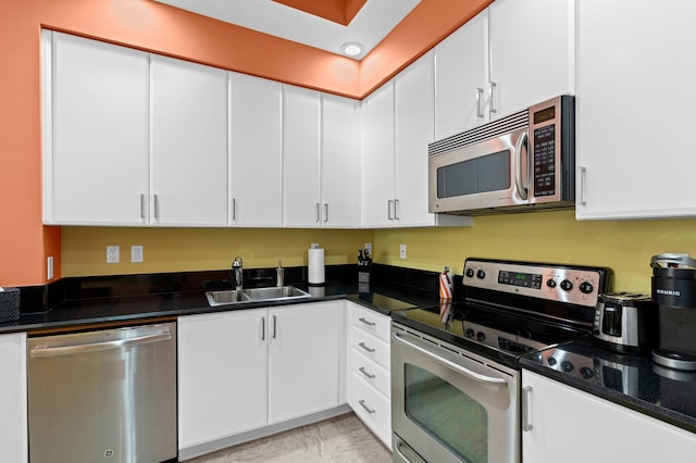 kitchen with marble finish floor, appliances with stainless steel finishes, a sink, and white cabinets