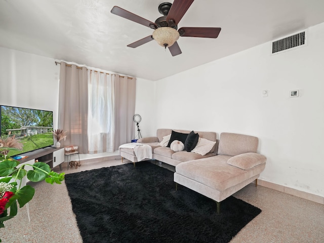 living area with speckled floor, a ceiling fan, visible vents, and baseboards