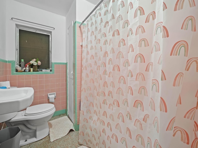 bathroom with toilet, a wainscoted wall, speckled floor, tile walls, and a shower with curtain