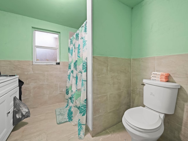 full bath featuring toilet, a shower with curtain, tile walls, and wainscoting