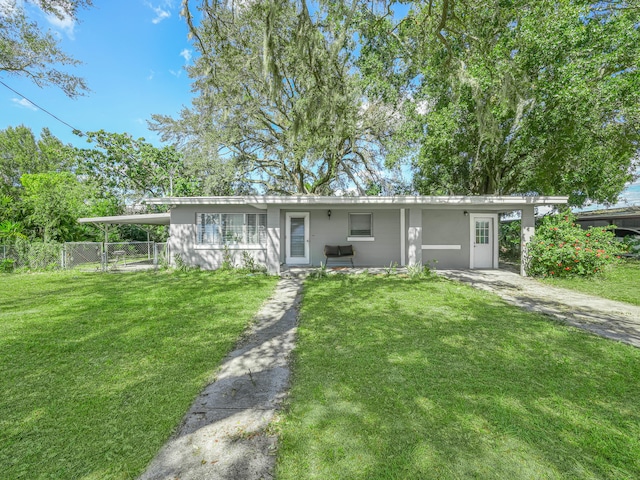 ranch-style home featuring fence and a front lawn