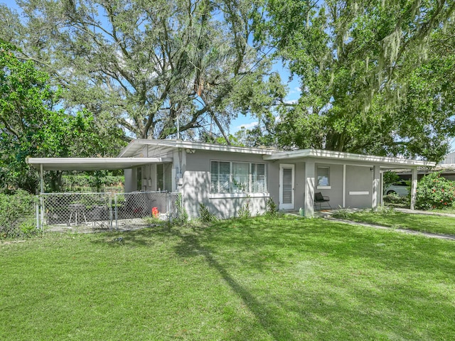 view of front of house featuring an attached carport, a front yard, fence, and a gate