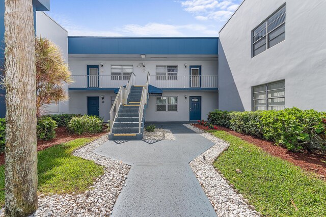 exterior space featuring stairway and stucco siding