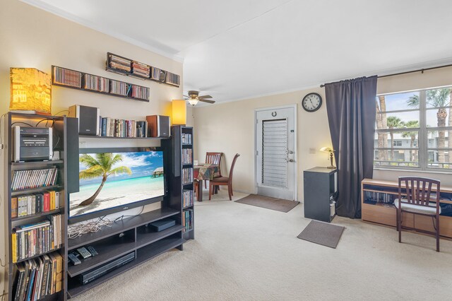 living area with carpet, ornamental molding, and a ceiling fan