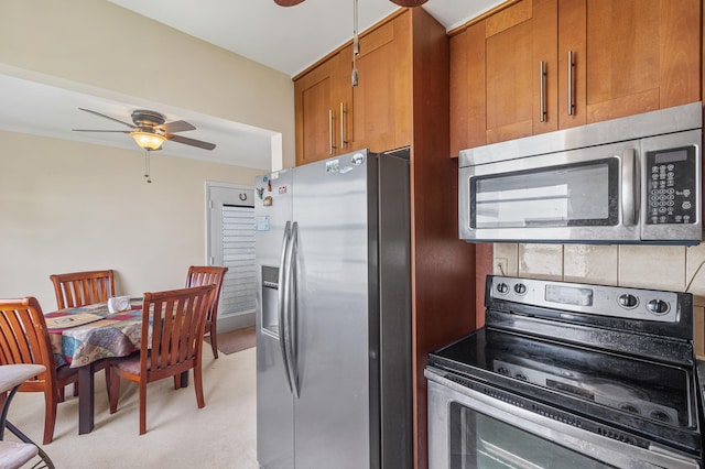 kitchen with ceiling fan, brown cabinetry, tasteful backsplash, and stainless steel appliances