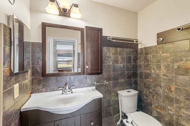 bathroom featuring toilet, tile walls, and vanity