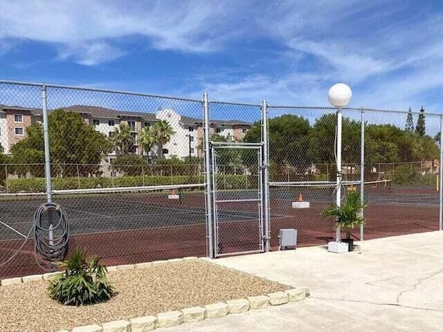 view of sport court with fence and a gate