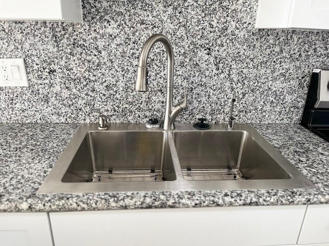 details featuring white cabinets and a sink