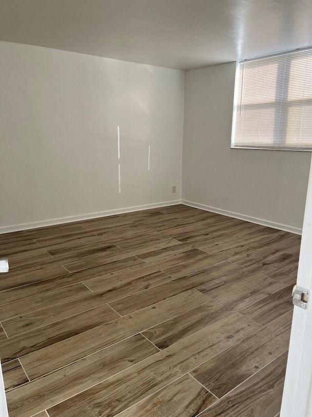 spare room with wood finished floors and baseboards