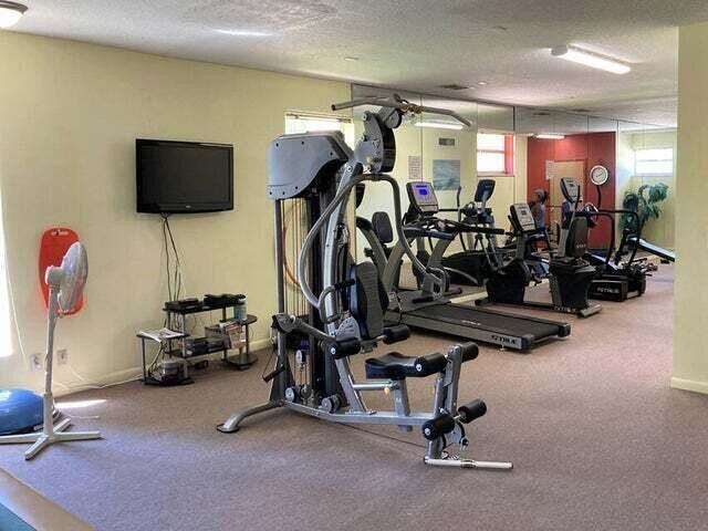 workout area featuring a textured ceiling and baseboards